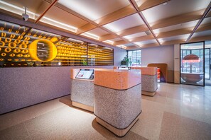 A modern reception area with a unique wall design, a digital information kiosk, and a spacious layout. - Orange Hotel Guangzhou Yuexiu Park (Guangzhou)