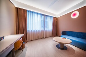 A modern hotel room with a desk, a round table, a sofa, and a large window with curtains. - Orange Hotel Guangzhou Yuexiu Park (Guangzhou)