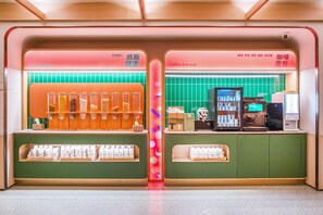 A cafe with a green counter, a coffee machine, and various food items displayed. - Orange Hotel Guangzhou Yuexiu Park (Guangzhou)