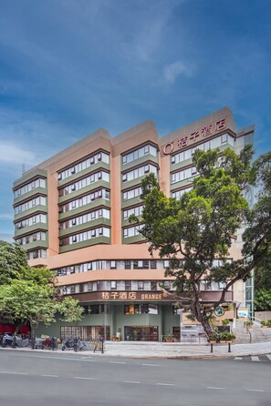 Um hotel de vários andares com fachada moderna, apresentando uma placa destacada para 'Cixi Hotel Orange'.