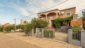 Ein zweistöckiges Haus mit Balkon, befahrbarer Allee und Satellitenschüssel.