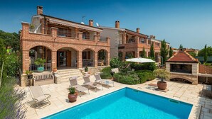 A two-story brick house with a swimming pool, outdoor seating, and a barbecue area. - Awesome home in Kastelir (Kastelir)