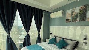 Une chambre moderne avec un grand lit, des rideaux foncés, une vue sur la ville et un climatiseur fixé au mur.