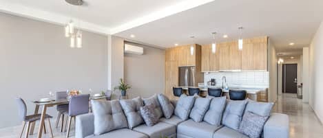 Ein modernes Wohnzimmer mit Ecksofa, Essbereich und Küche.