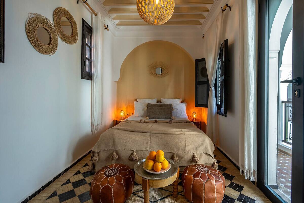 Ein gemütliches Schlafzimmer mit einem Bett, einem kleinen Tisch mit Orangen und einem dekorativen Wandbild.