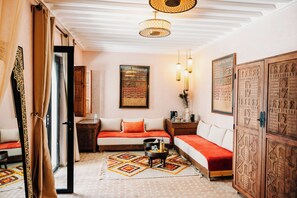 Une pièce confortable avec un lit, une petite table, une table de chevet et des panneaux décoratifs.