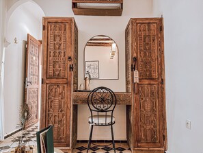 A room with a wooden desk, a chair, and a mirror on the wall. - Riad Nelia Signature (Marrakech)