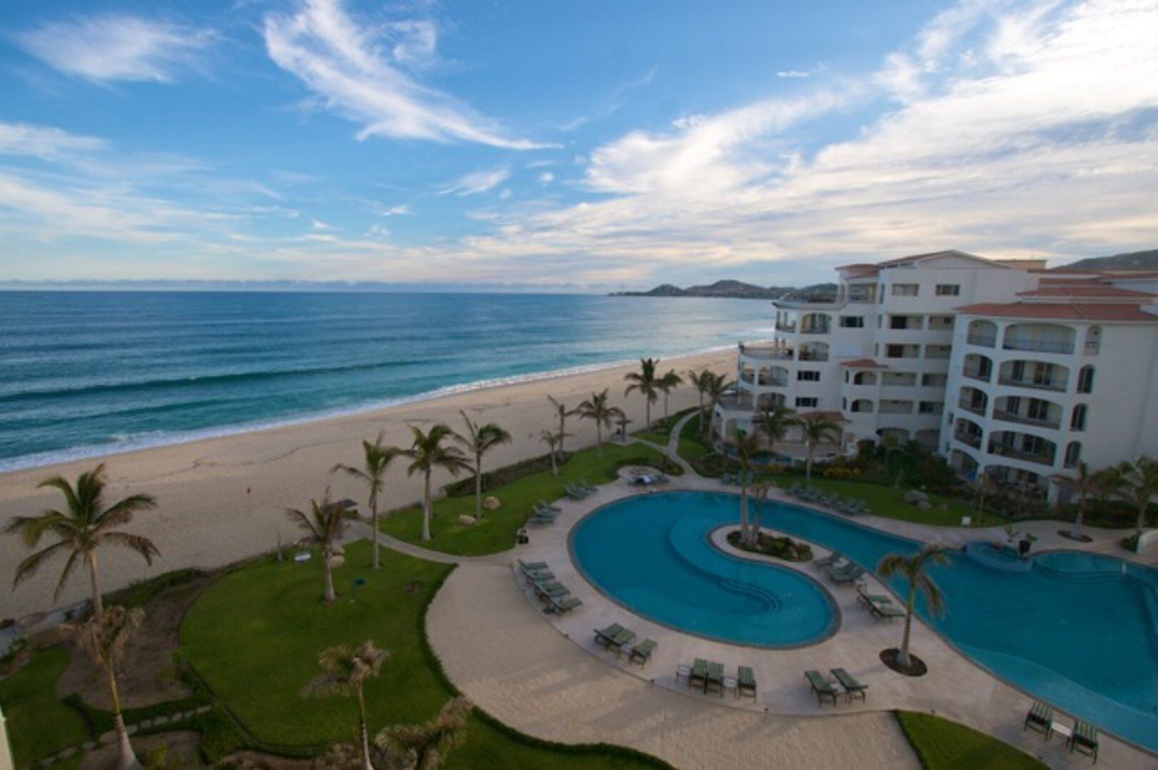 Ein Resort mit großem Pool, einem Strand und Blick aufs Meer.