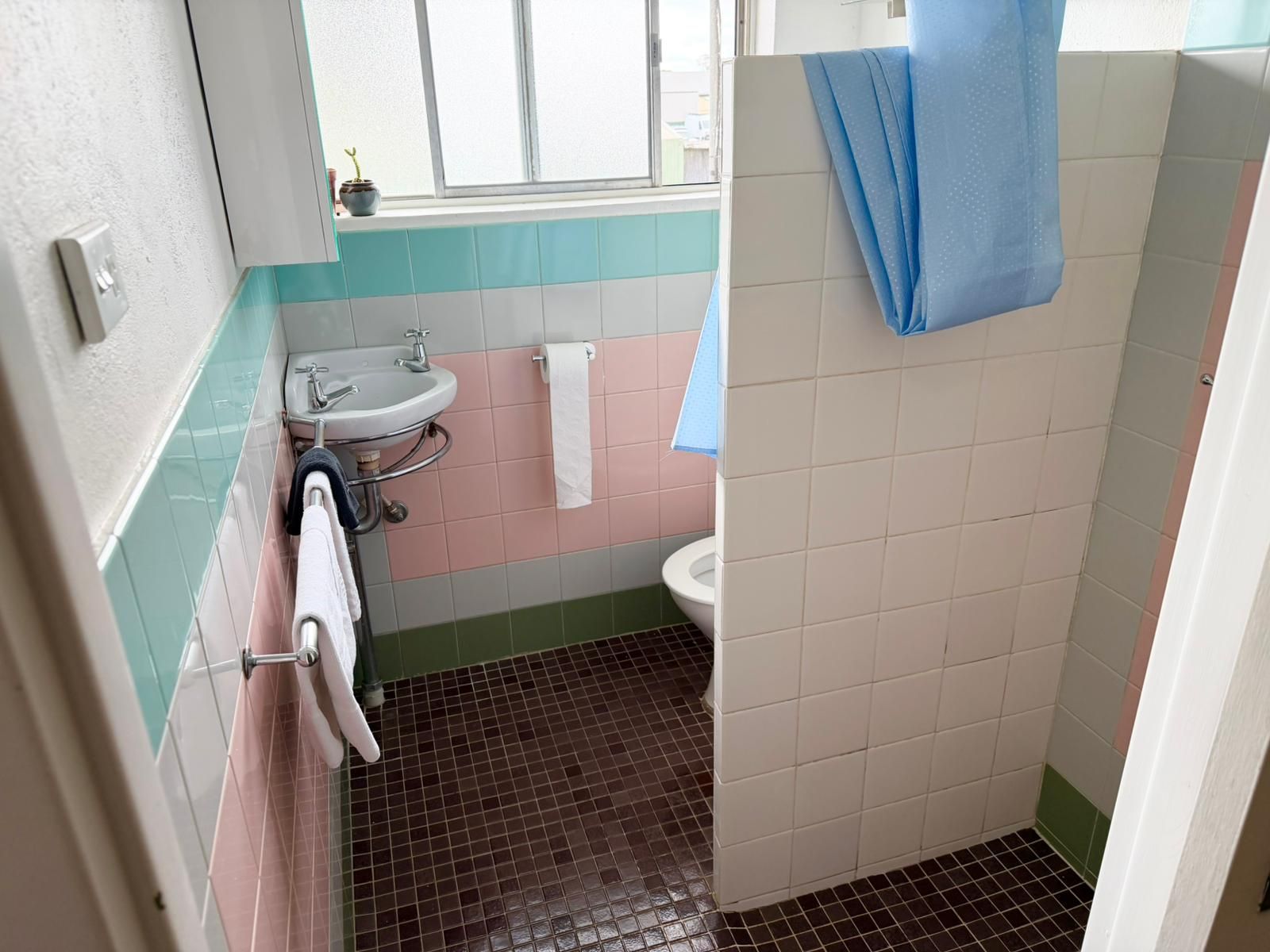 A bathroom with a sink, toilet, and a window.