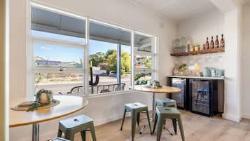 A cafe with a large window, a coffee bar, and a refrigerator.
