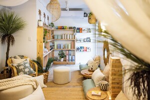 A cozy living room with a wooden bookshelf, a comfortable seating area, and a small table with decorative items.