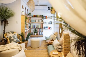 Una sala de estar acogedora con una estantería de madera, un rincón de descanso confortable y una pequeña mesa con adornos.