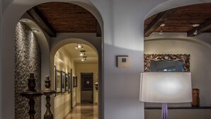 A hallway with a wooden ceiling, a marble floor, and a wall-mounted thermostat. - Tortuga TBB 2401 (San José del Cabo)