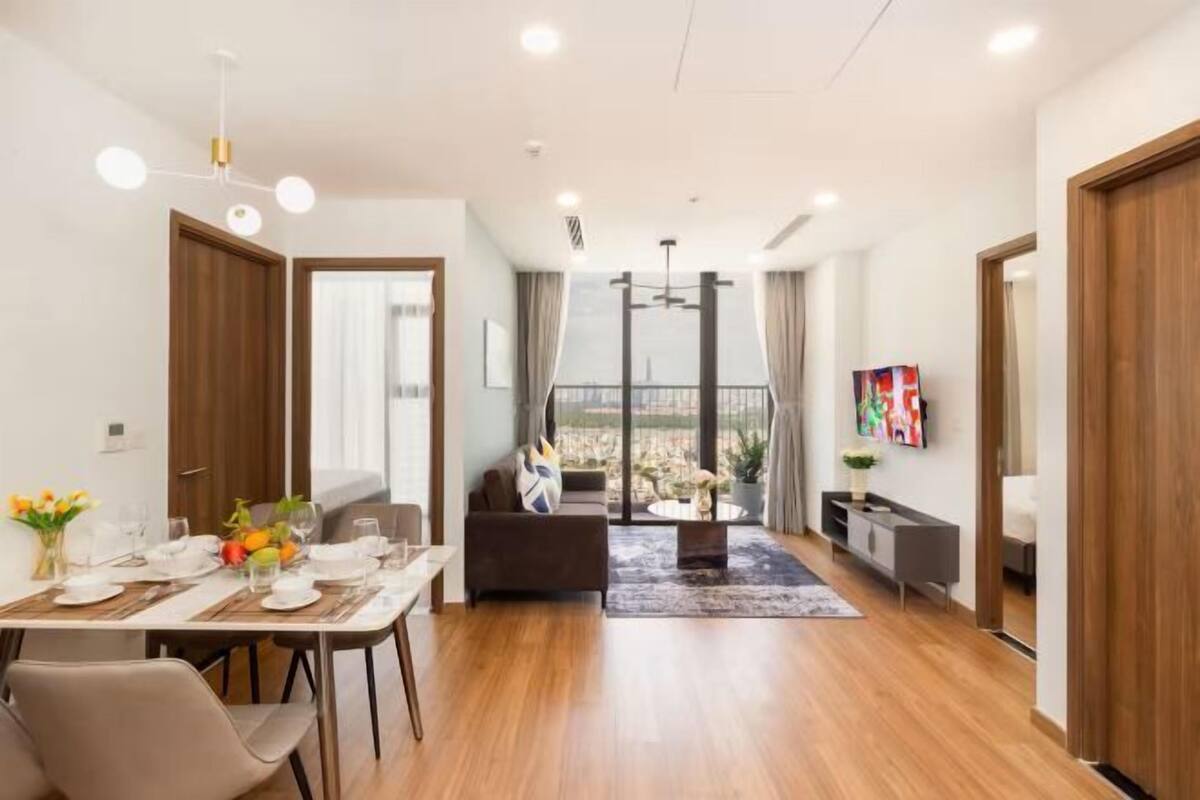 Una sala de estar moderna con comedor, sofá, televisor y vistas de la ciudad.