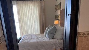 A bathroom with a bathtub, a bed, and a shower area. - Tortuga Bay TBB 2502 (San José del Cabo)
