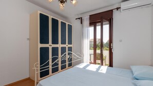 Un dormitorio con cama, armario y balcón.