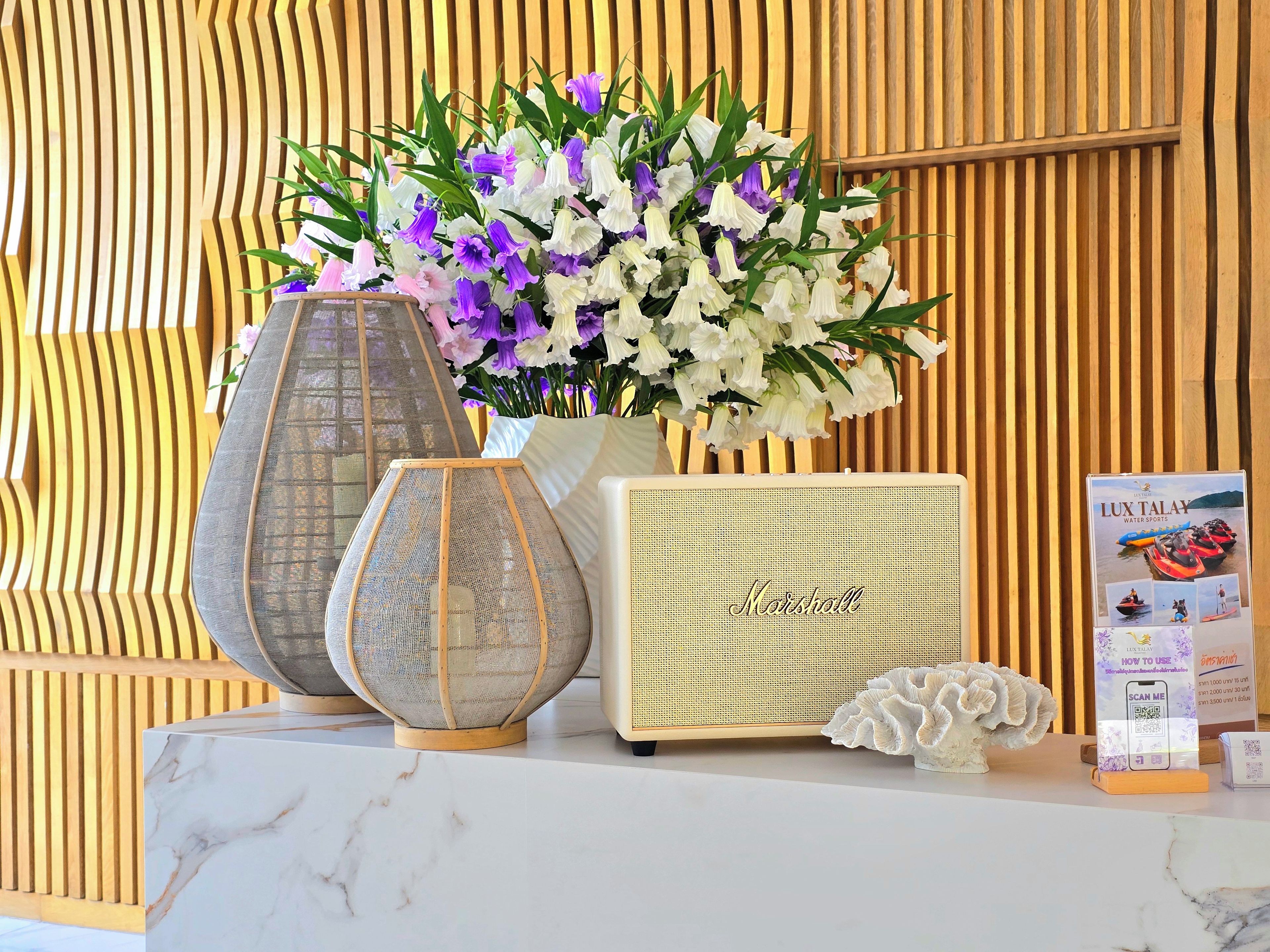 A marble table with a decorative vase, a framed item with text, and a QR code sign.