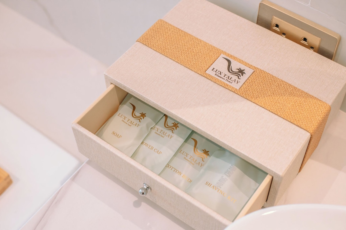 A drawer with a beige box labeled 'LUX TALAY' containing various items.