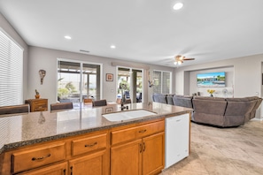 A modern kitchen with granite countertops, wooden cabinets, and a built-in dishwasher.