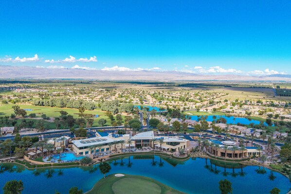 An aerial view of a resort with multiple swimming pools, golf courses, and residential buildings.