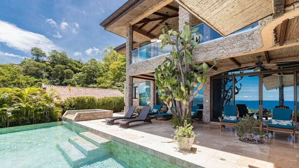 A modern house with a swimming pool, outdoor seating, and a view of the ocean. - Playa Hermosa Villa • 3BR • Infinity Pool & Swim-Up Bar • Ocean Views (Playa Hermosa)
