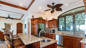 A spacious kitchen with granite countertops, wooden cabinetry, and a large island with seating. - Playa Hermosa Villa • 3BR • Infinity Pool & Swim-Up Bar • Ocean Views (Playa Hermosa)