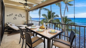 A balcony with a view of the ocean, wicker furniture, and a ceiling fan. - Kona Bali Kai#307 (Kailua-Kona)