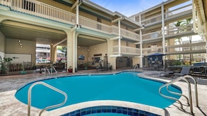 A multi-level pool area with a clear blue pool, multiple balconies, and outdoor seating. - Kona Bali Kai#307 (Kailua-Kona)