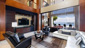 A spacious living area with a large TV, comfortable seating, and a view of the outdoors.