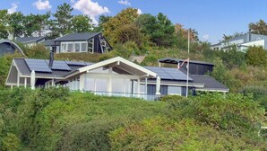 A modern house with solar panels, large windows, and a covered porch. - Stunning home in Ebeltoft with sauna (Ebeltoft)