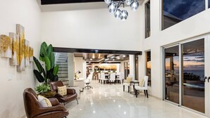 A spacious living area with a dining area, large windows, and a view of the ocean. - Playa Hermosa Villa • 4BR • Infinity Pool • Ocean & Bay View • Recently Renovated • Sunset Ridge (Playa Hermosa)
