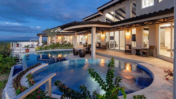 A modern house with a large swimming pool, outdoor seating, and a covered patio area. - Playa Hermosa Villa • 4BR • Infinity Pool • Ocean & Bay View • Recently Renovated • Sunset Ridge (Playa Hermosa)