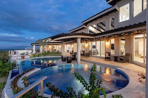 A modern house with a large swimming pool, outdoor seating, and a covered patio area. - Playa Hermosa Villa • 4BR • Infinity Pool • Ocean & Bay View • Recently Renovated • Sunset Ridge (Playa Hermosa)