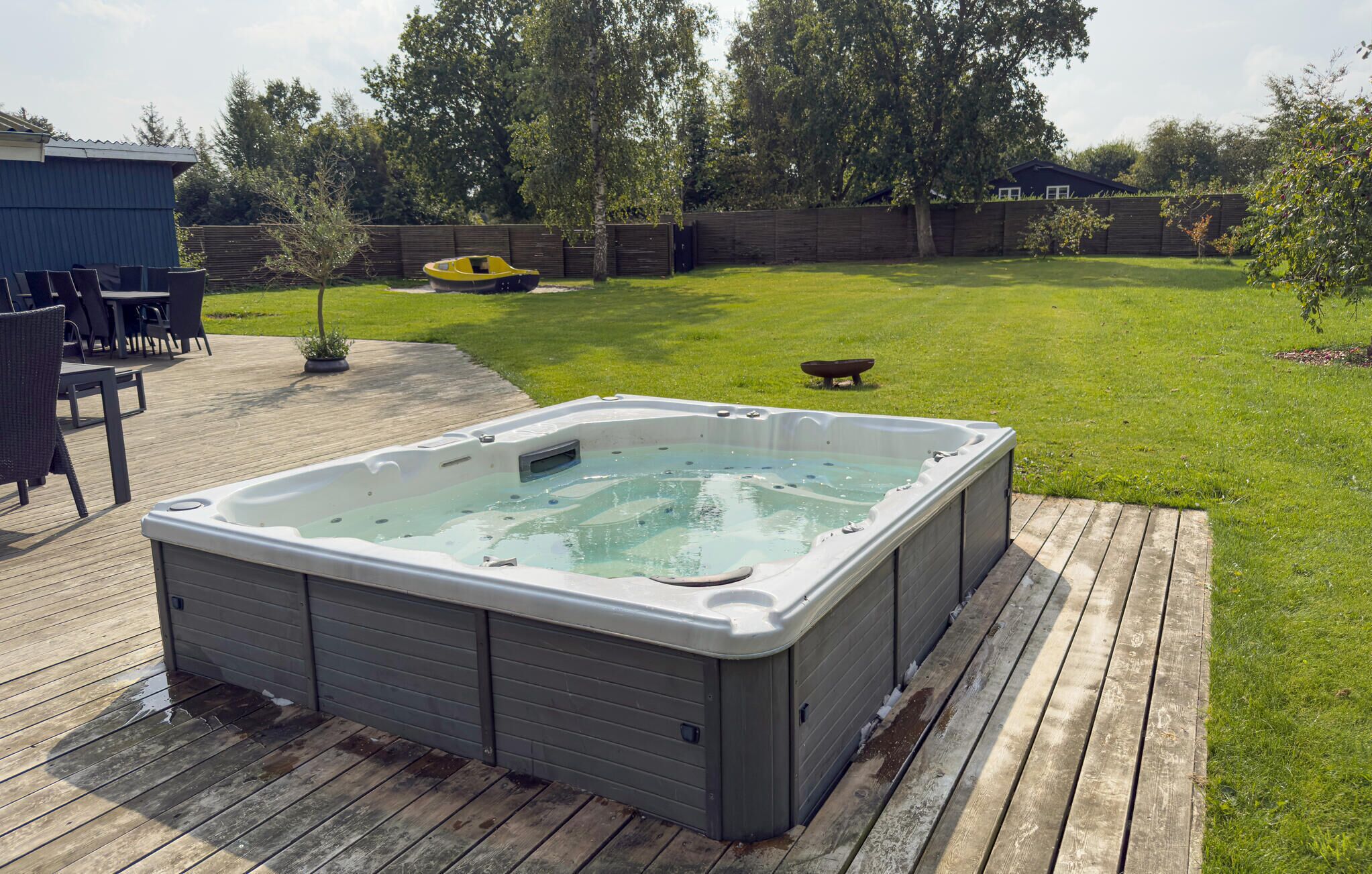 Ein Whirlpool auf einer Holterrasse mit einem Rasen im Hintergrund.