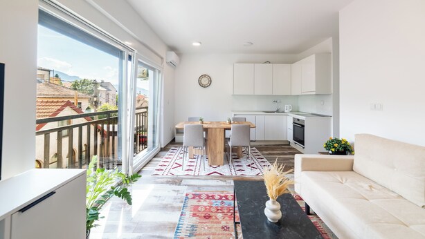 Un appartement moderne doté d’un balcon, d’un coin repas, d’une cuisine et d’un salon.