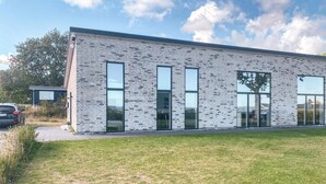 A modern building with a brick facade, large windows, and a flat roof. - Pet friendly home in Allingåbro with sauna (Allingåbro)