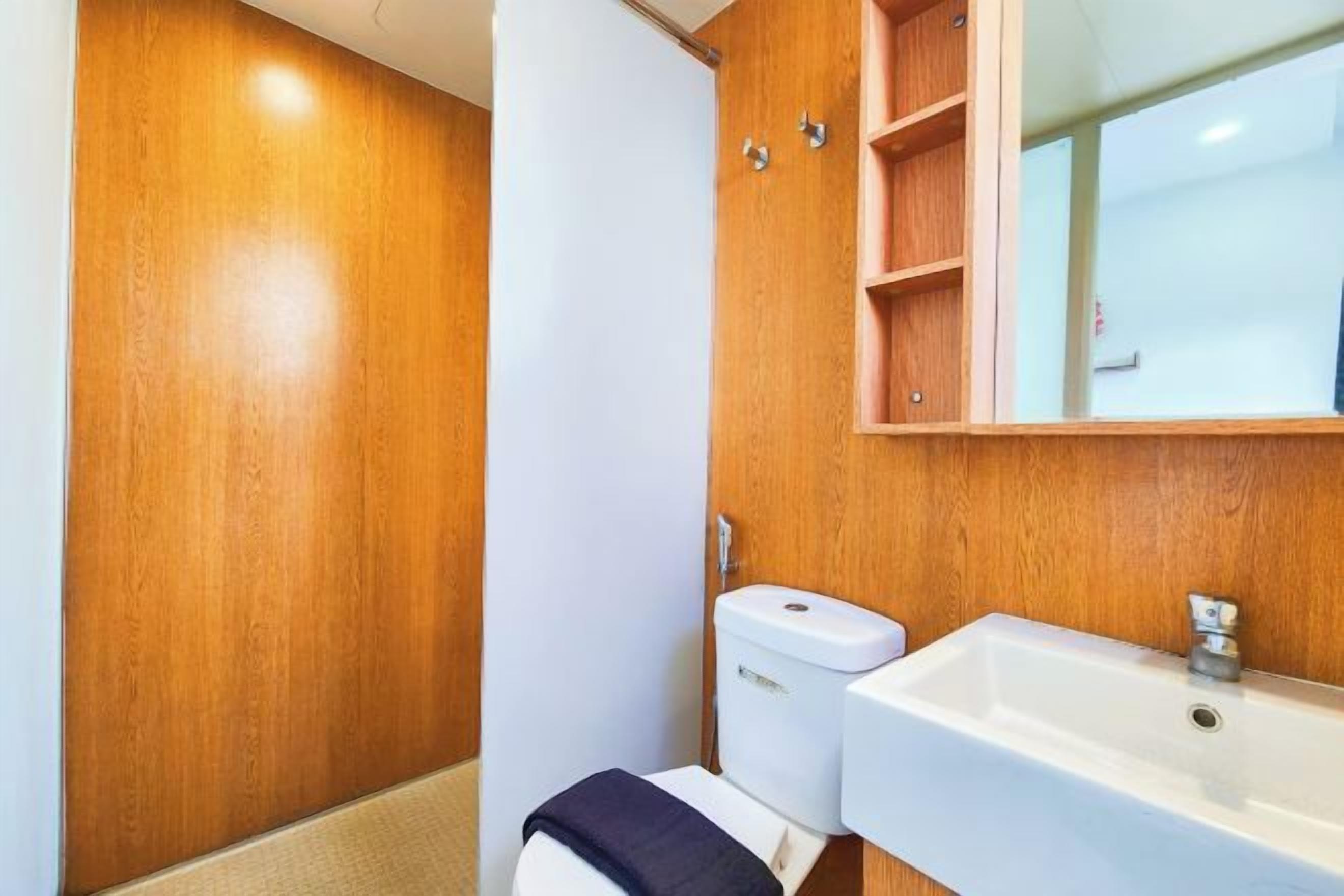 Un bagno con un mobile lavabo in legno, un lavandino bianco e un WC.