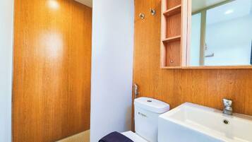 Un bagno con un mobile lavabo in legno, un lavandino bianco e un WC.