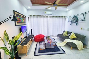Una sala de estar moderna con ventilador de techo, un escritorio con computadora, un sofá con cojines y una ventana con cortinas.