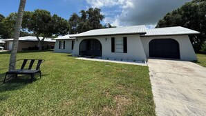Uma casa moderna com garagem, varanda coberta e gramado.