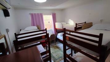 Une chambre de dortoir avec des lits superposés, un bureau et une chaise.