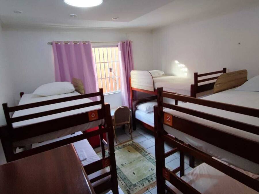 Une chambre de dortoir avec des lits superposés, un bureau et une chaise.