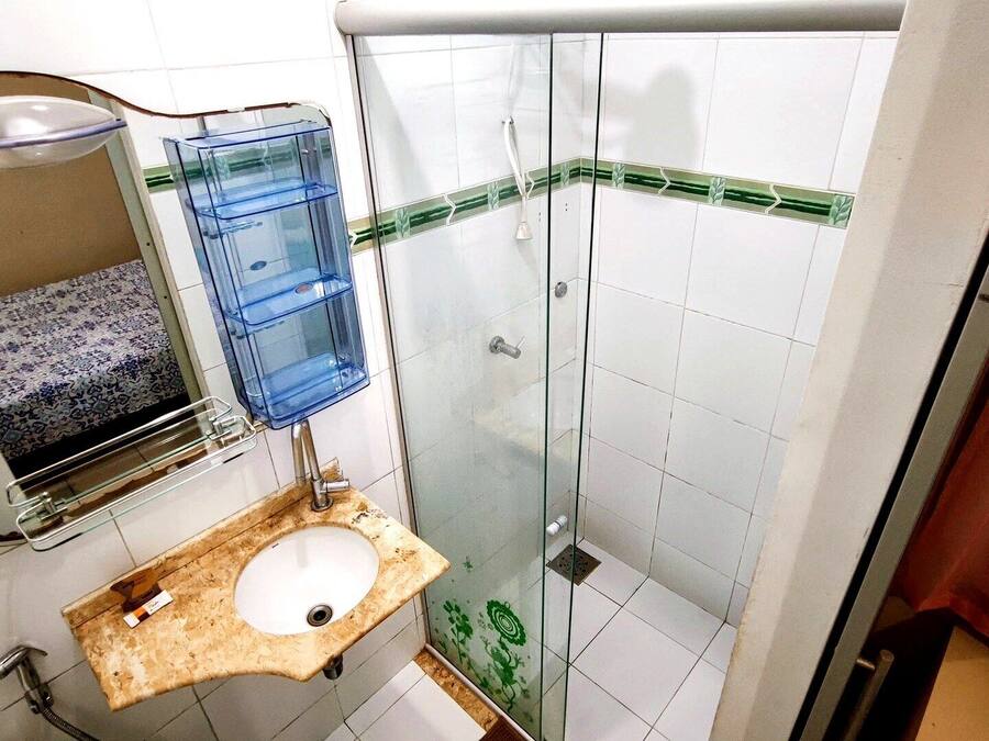 A bathroom with a sink, mirror, and shower.