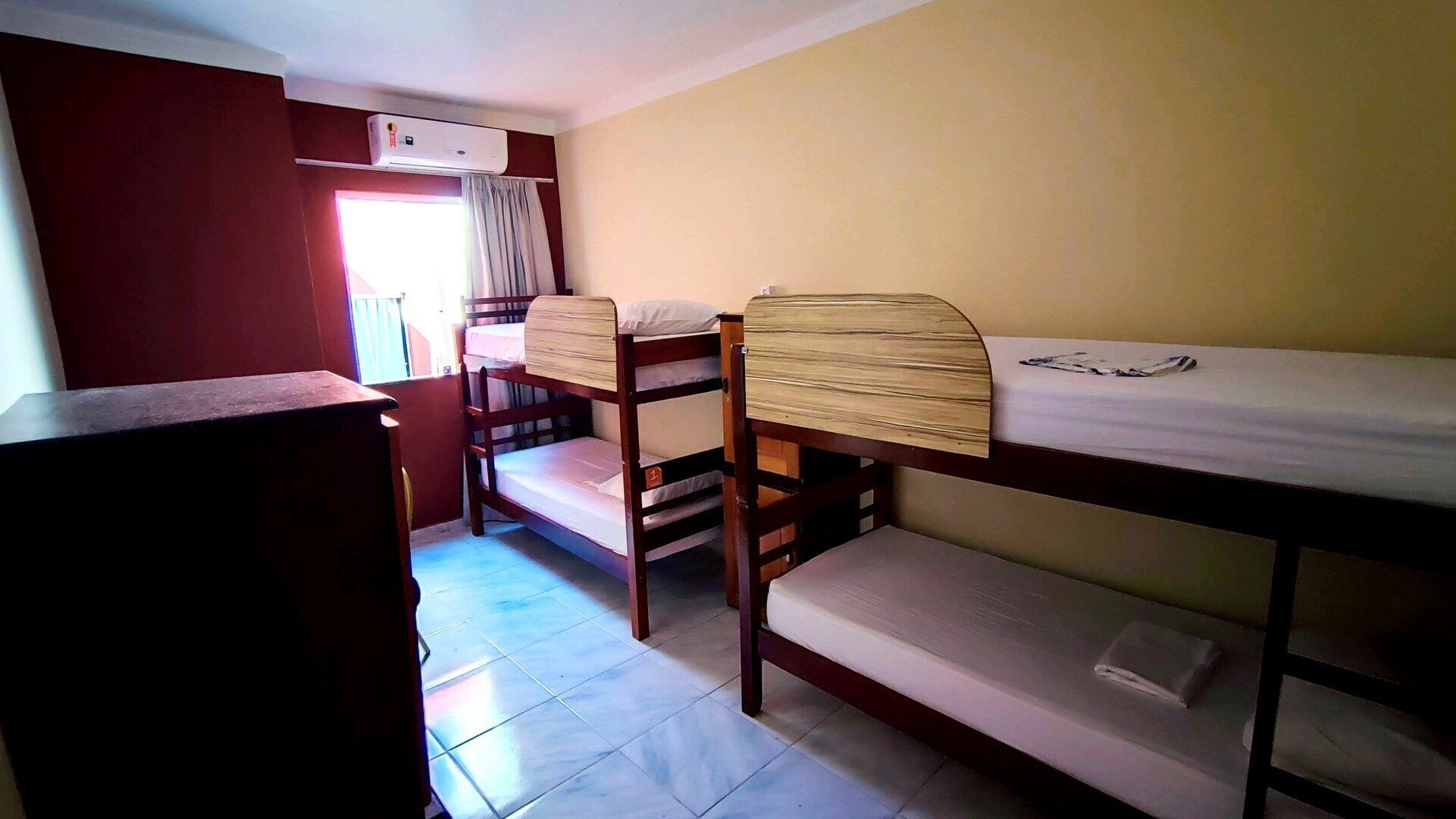 Un dormitorio con literas, un escritorio y una ventana con cortinas.