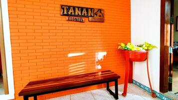 A hostel with a brick wall and a wooden bench.