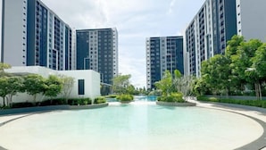 A residential complex with high-rise buildings, a central swimming pool, and landscaped greenery. - Splash Mania Homestay (Tanjung Dua Belas)