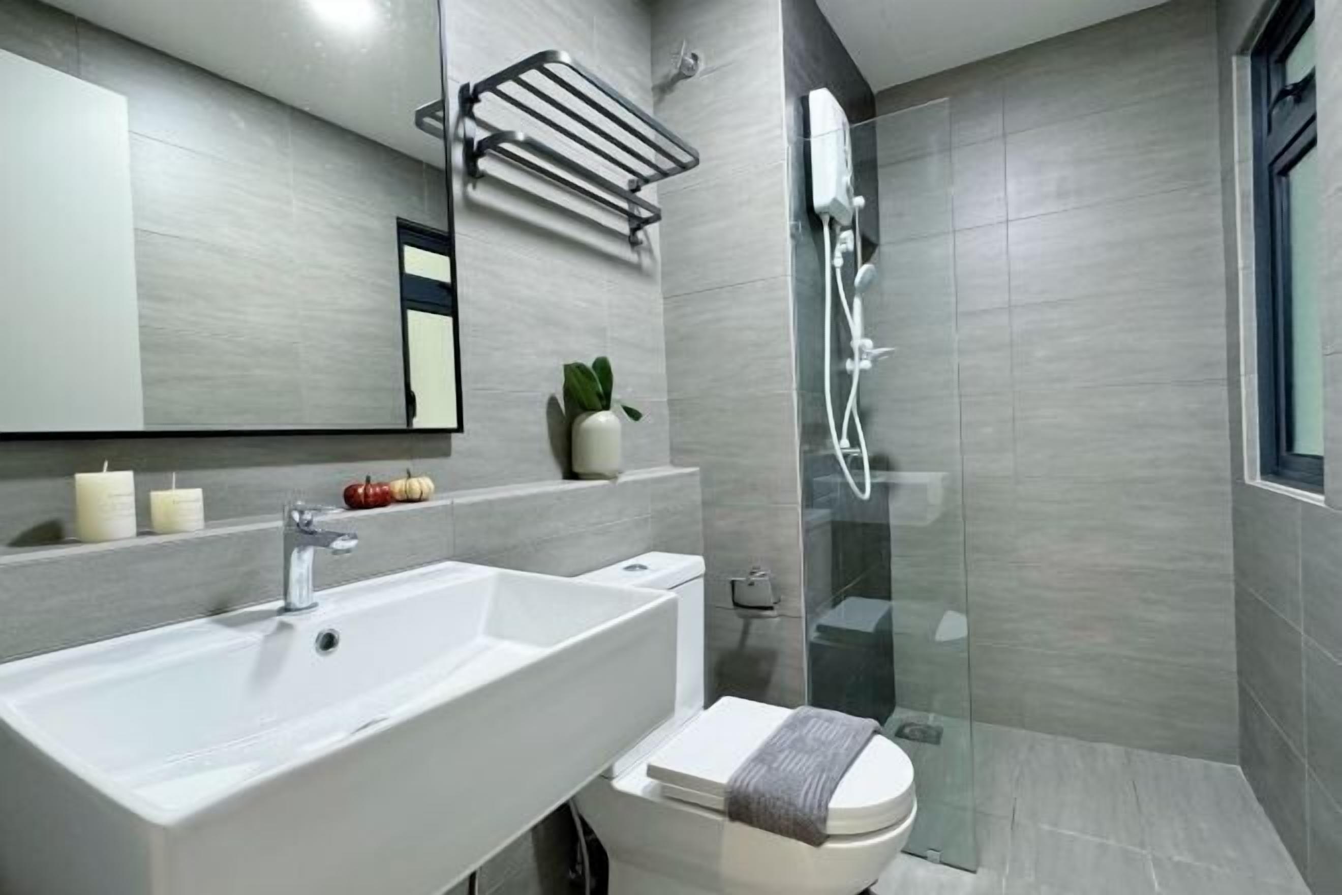 Ein modernes Badezimmer mit einem großen weißen Waschbecken, einer Toilette und einer Duschkabine aus Glas.