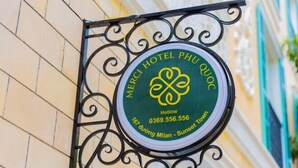 A hotel sign with a circular design, featuring a logo and contact information. - Merci Sunset Town Phu Quoc (Phu Quoc Island)