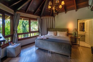 Un dormitorio con cama, mesita de noche, lámpara, espejo y ventana con cortinas.