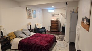 Ein Schlafzimmer mit Bett, Nachttischen, einem Schminktisch und einem Sessel.